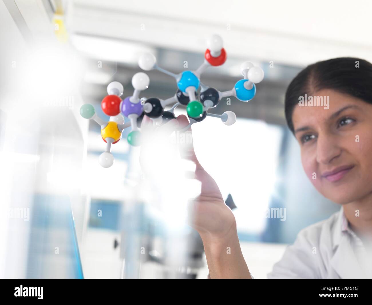 PROPERTY RELEASED. MODEL RELEASED. Female Asian using a molecular model to understand a chemical formula Stock Photo