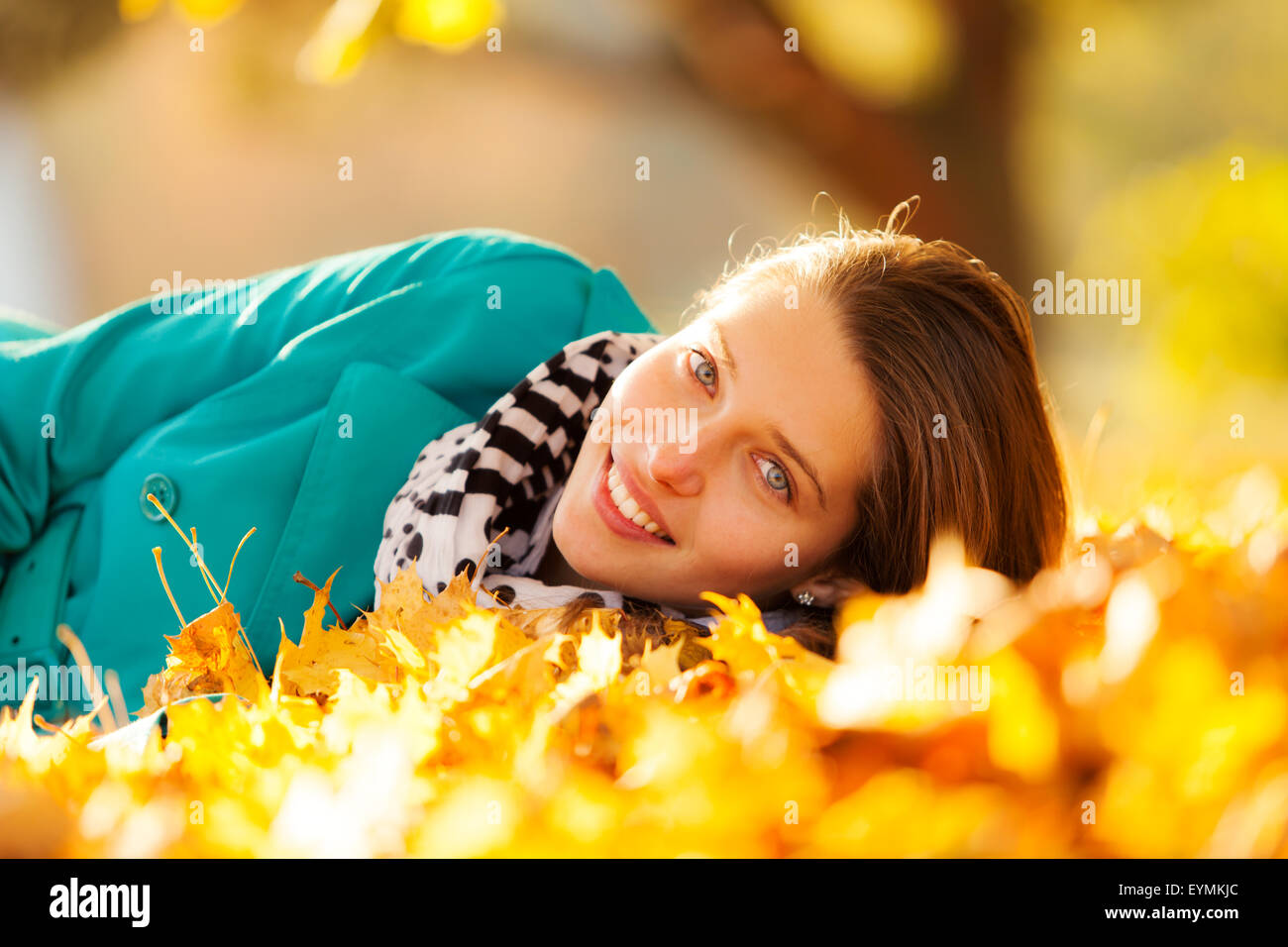 Beautiful girl lying in autumn leaves Stock Photo