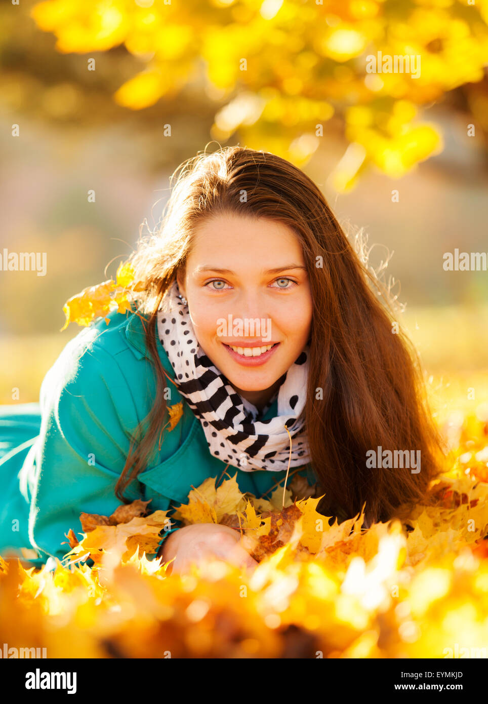 Beautiful girl lying in autumn leaves Stock Photo