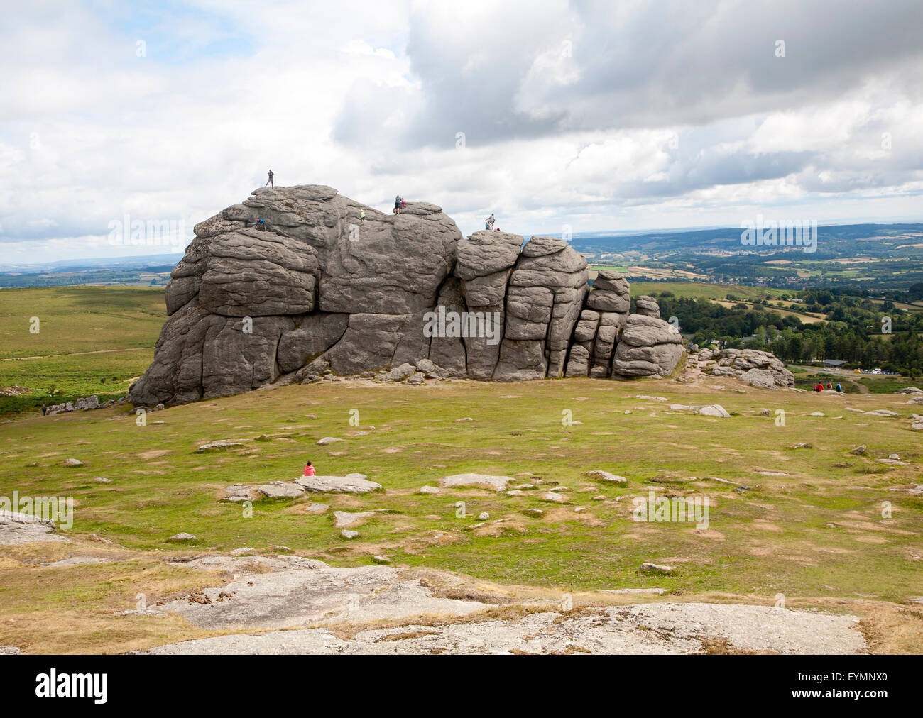 People scrambling on the granite tor of Haytor, Dartmoor national park, Devon, England, UK Stock Photo