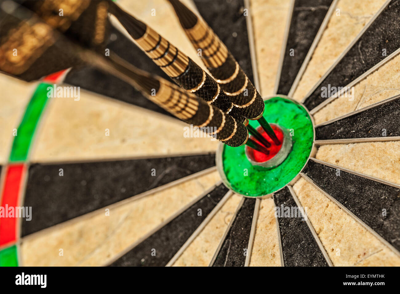 Success hitting target aim goal achievement concept background - three darts in bull's eye close up Stock Photo