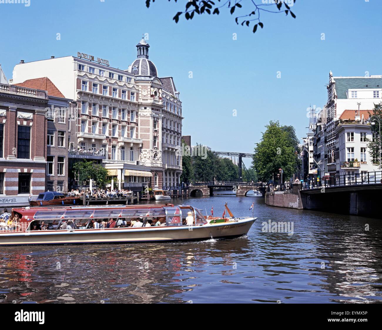 Tourist boat trip along the River Amstel with the Doelen hotel to the rear, Amsterdam, Holland, Netherlands, Europe. Stock Photo