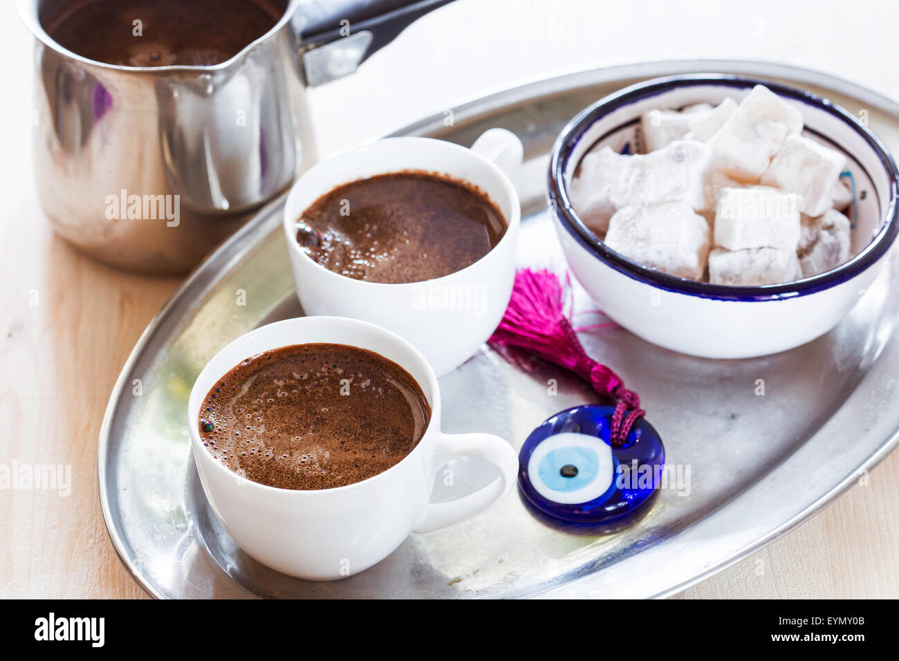 Cup of coffee on a metal tray with Turkish sweets and glass amulet Evil Eye Stock Photo