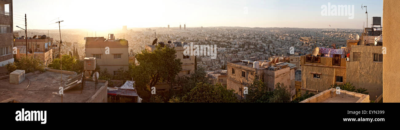 Amman city rooftops at dusk / sunset, shot into the sun from the Jebel al-Ashrafiyeh, one of Amman's seven hills. Stock Photo