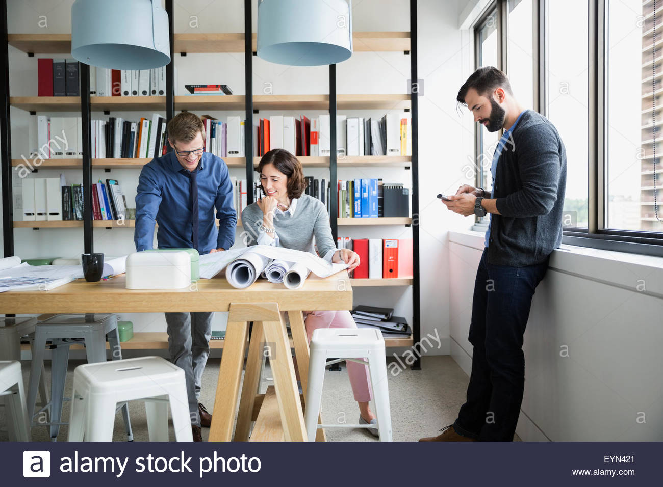 Architects meeting and reviewing blueprints in office Stock Photo