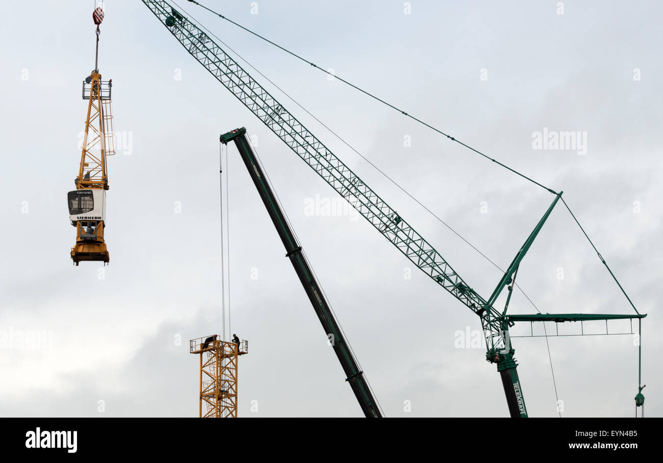 Construction workers dismantling tower crane Stock Photo