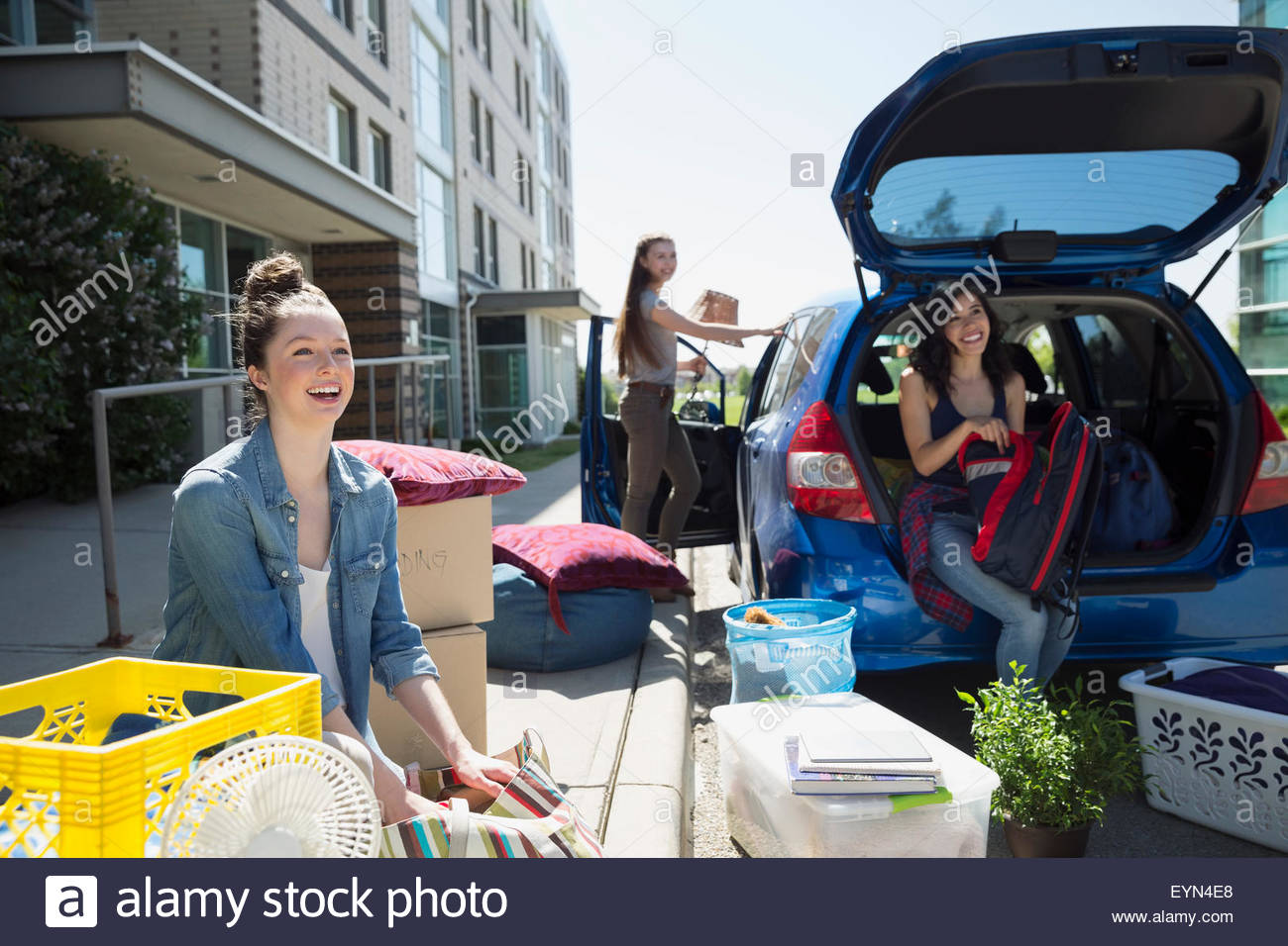 College students unloading car moving into college dorm Stock Photo