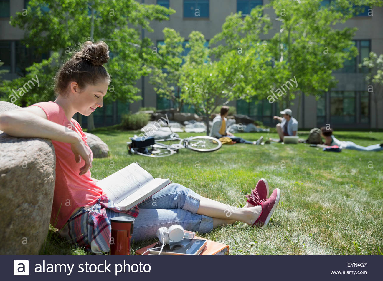 College student studying on sunny campus lawn Stock Photo