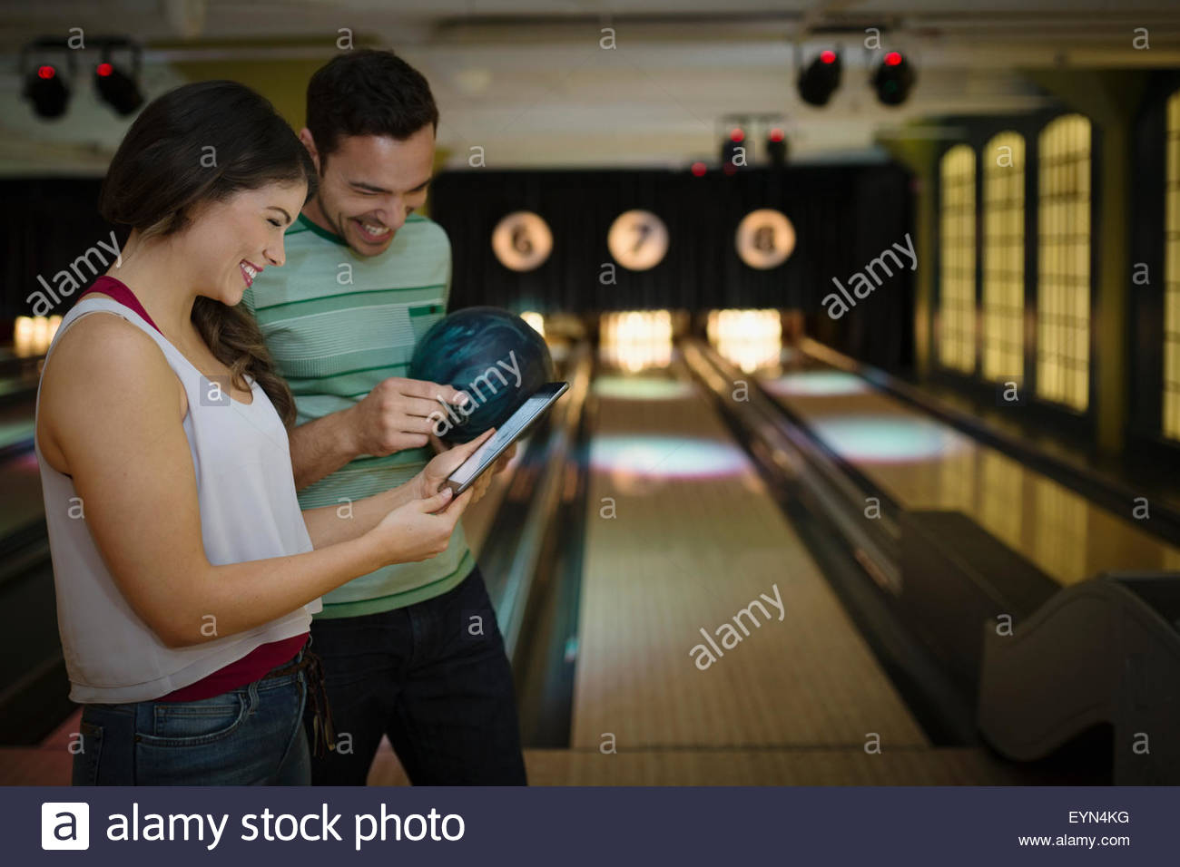 Young couple using digital tablet at bowling alley Stock Photo