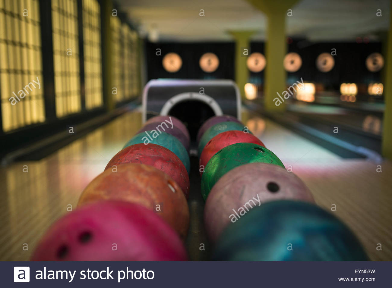 Multicolor bowling balls on rack at bowling alley Stock Photo