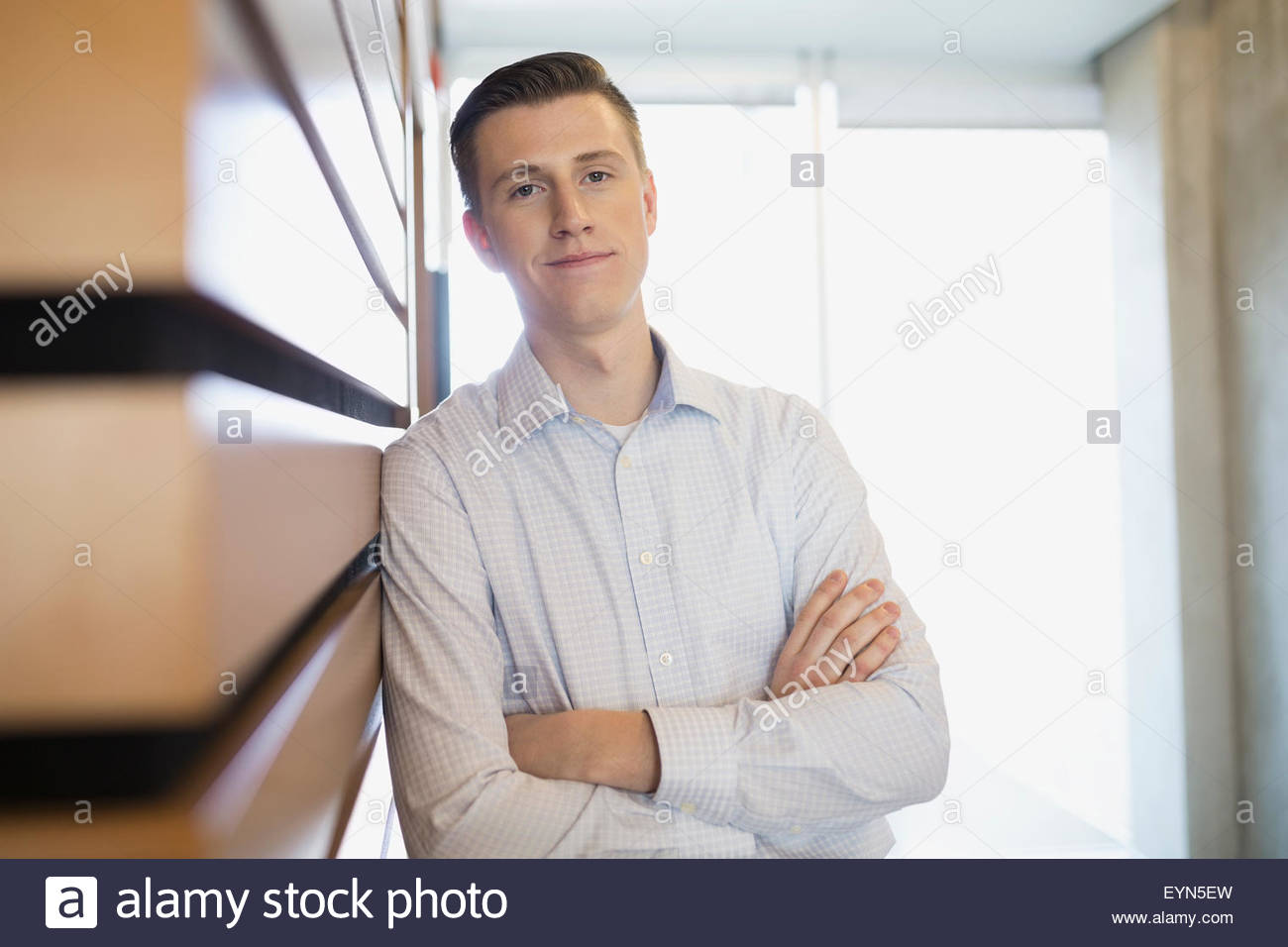 Portrait confident businessman with arms crossed leaning wall Stock Photo