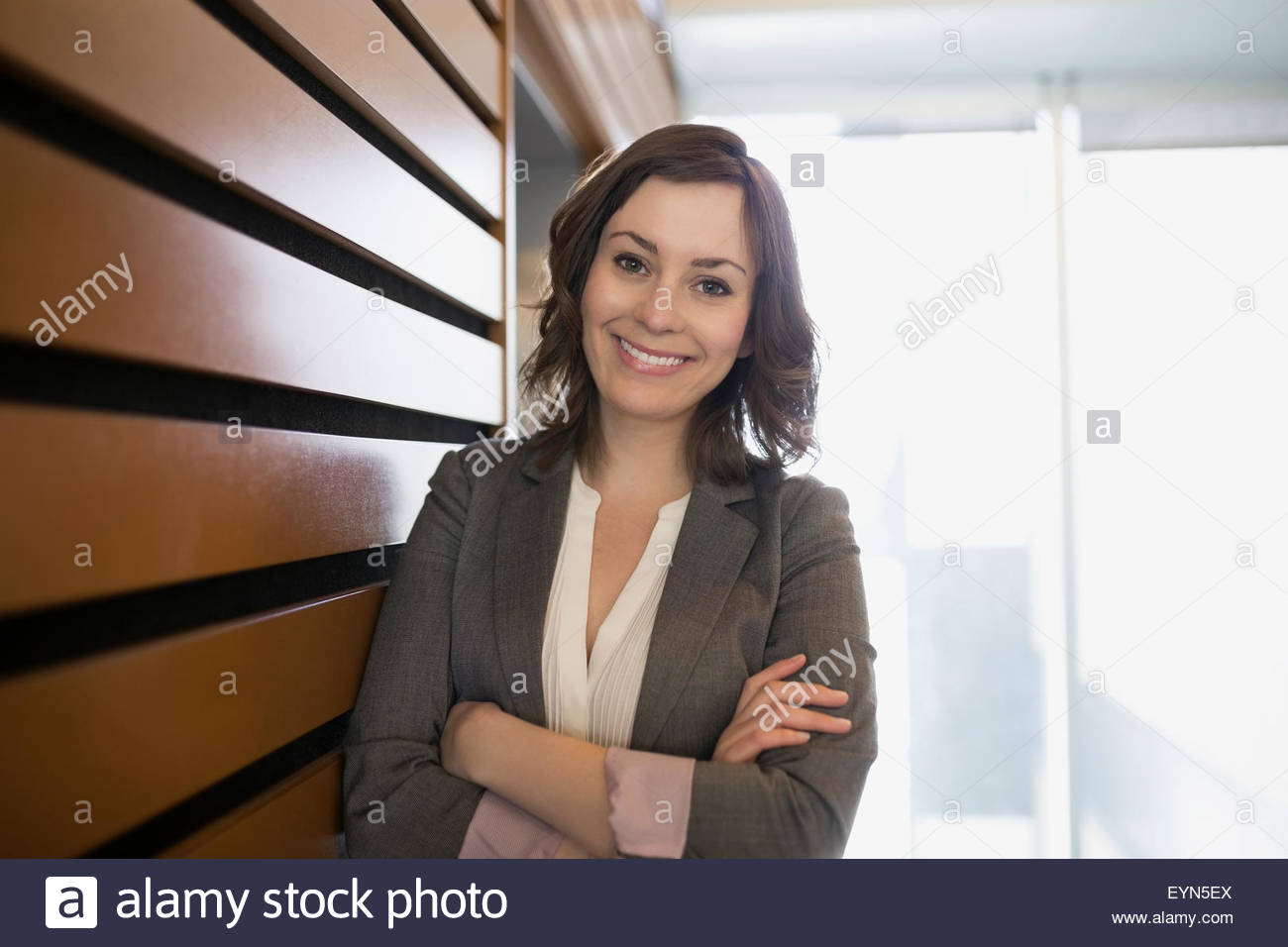 Portrait confident brunette businesswoman with arms crossed Stock Photo