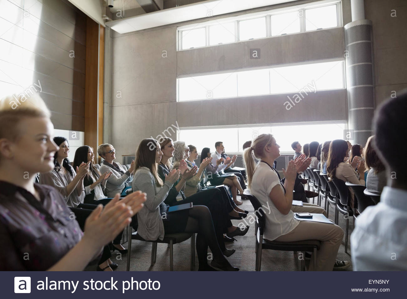 Students clapping in auditorium audience Stock Photo