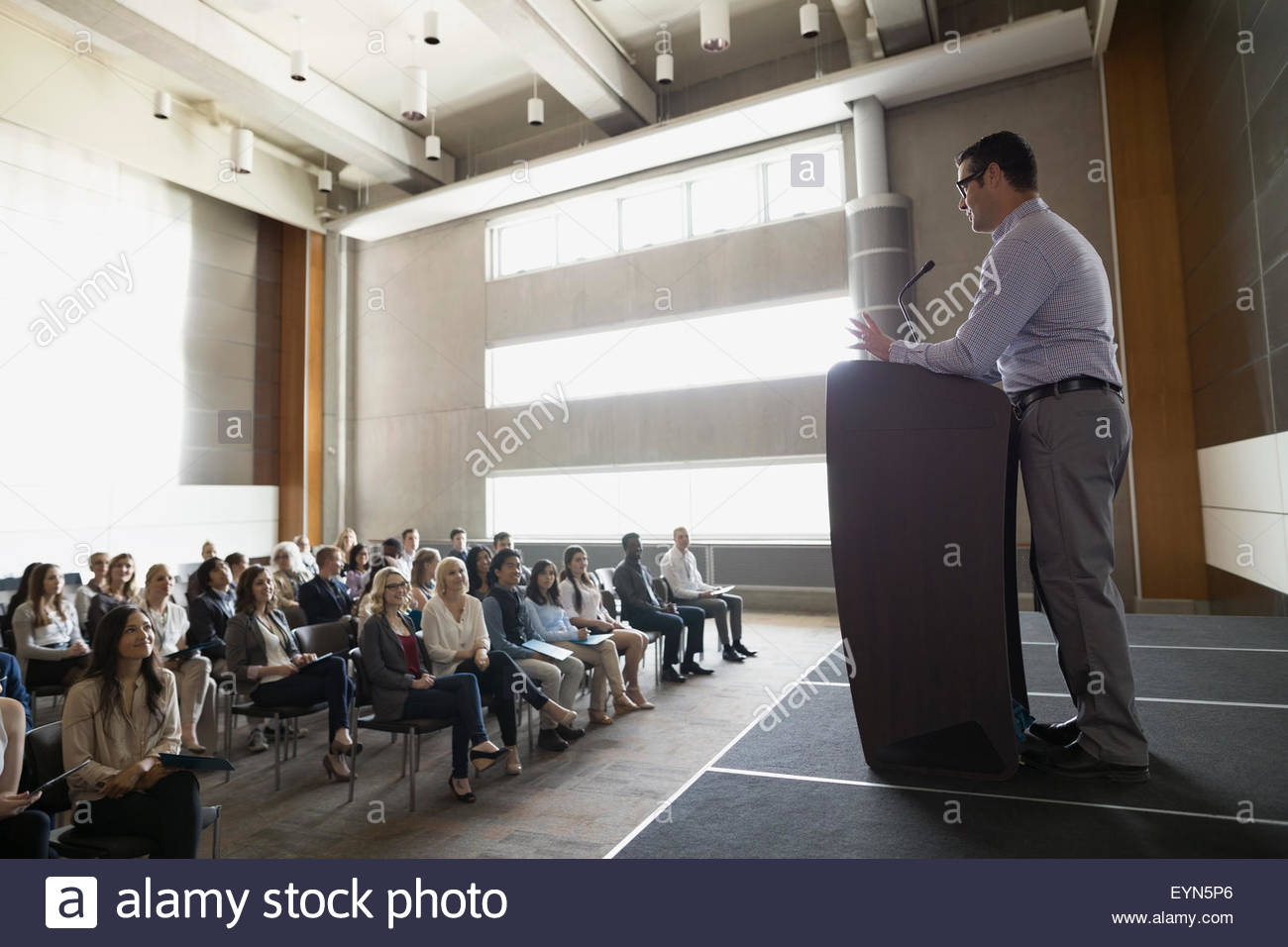 Professor at podium speaking to students in auditorium Stock Photo