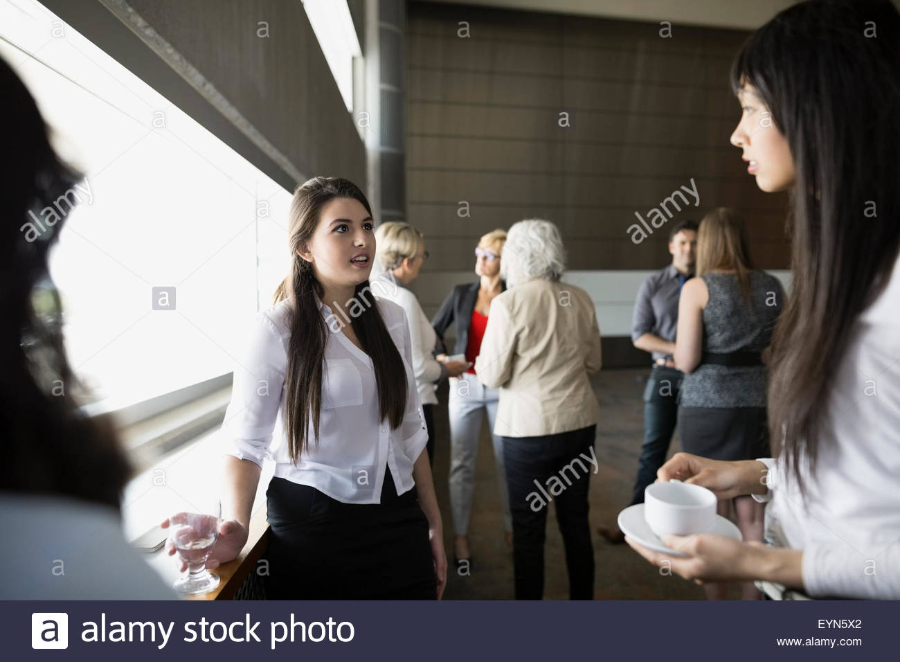 Women socializing in auditorium Stock Photo