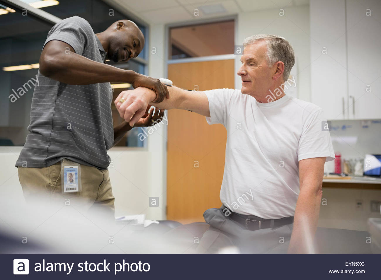 Physical therapist using electrodes on patient arm Stock Photo