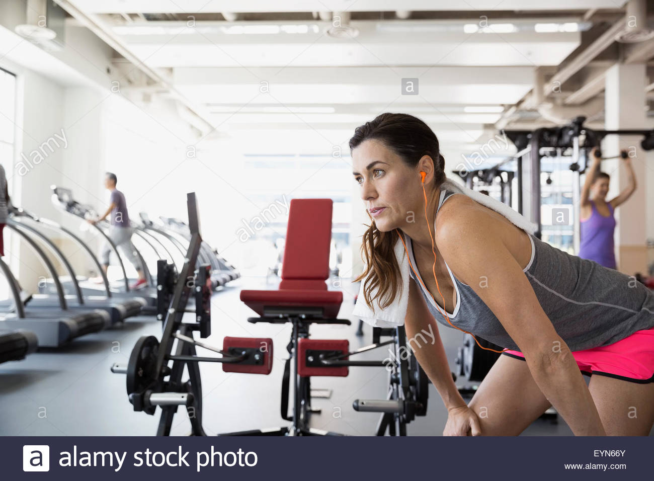 Woman resting with hands on knees at gym Stock Photo