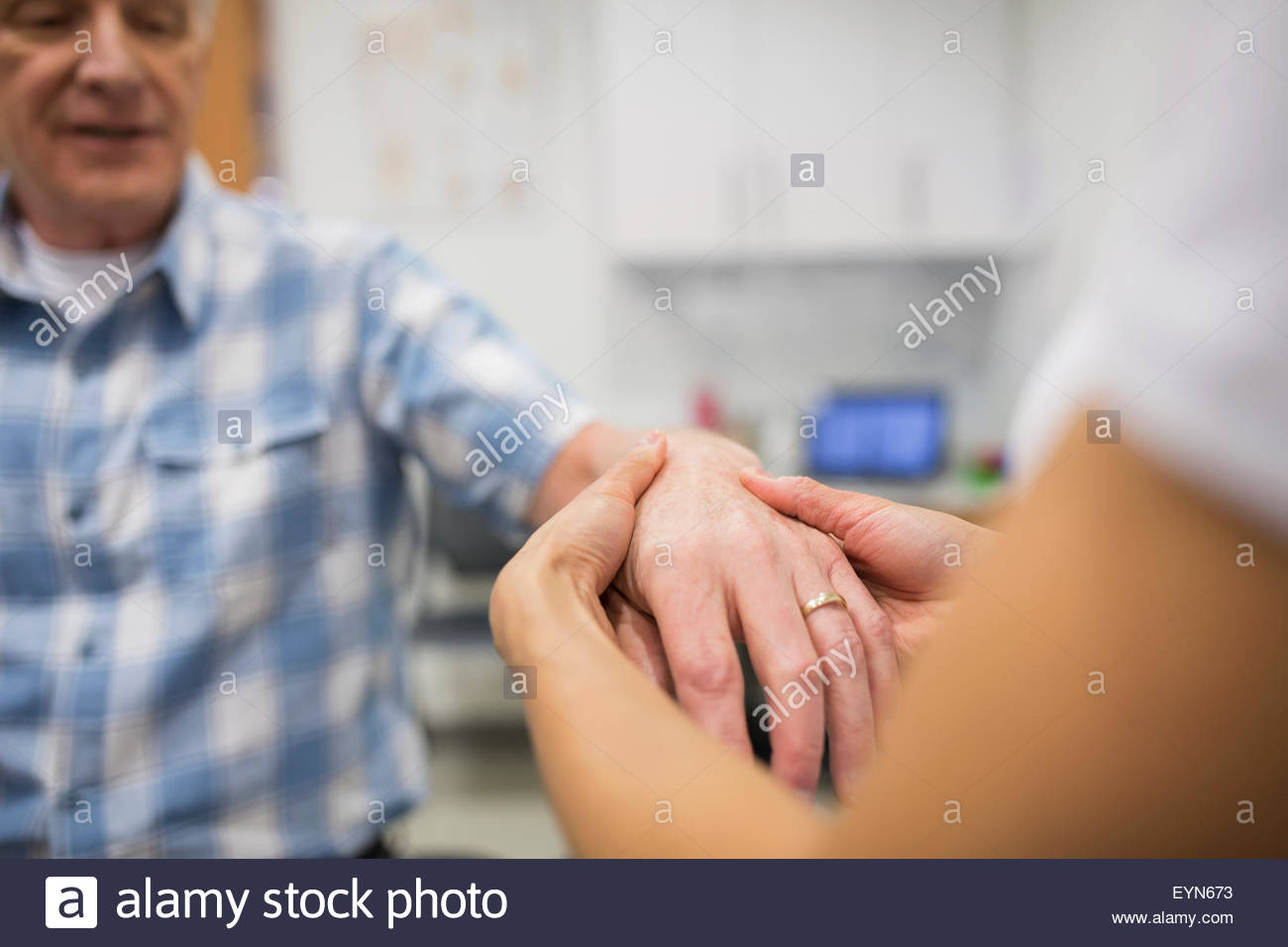 Close up physical therapist feeling patient hand Stock Photo