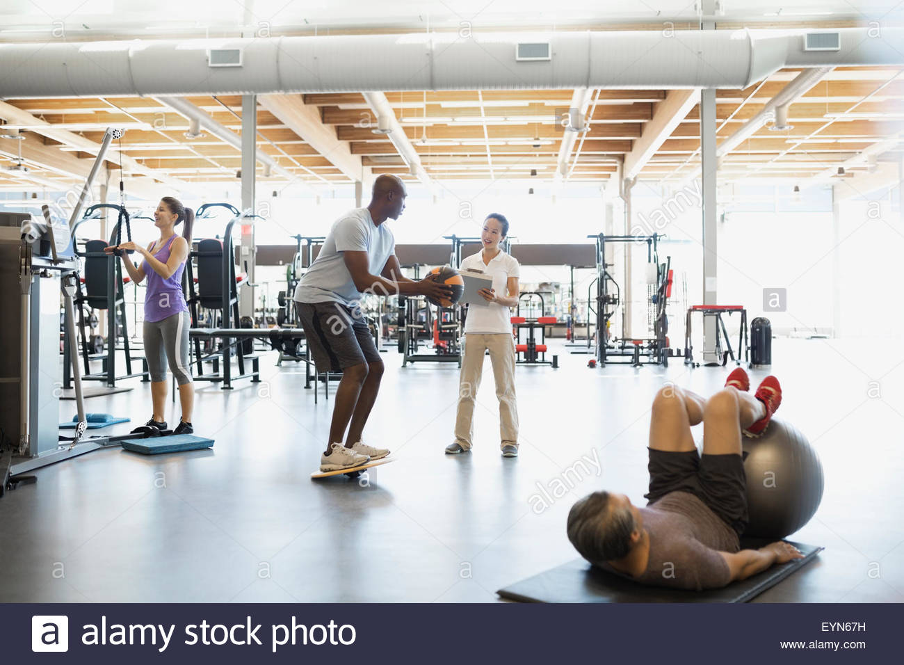 Physical therapist guiding patient with medicine ball gym Stock Photo
