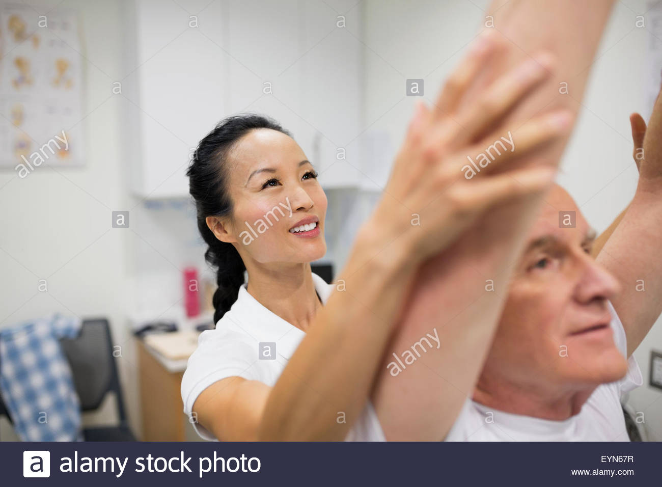 Physical therapist guiding patient with arms raised Stock Photo Alamy