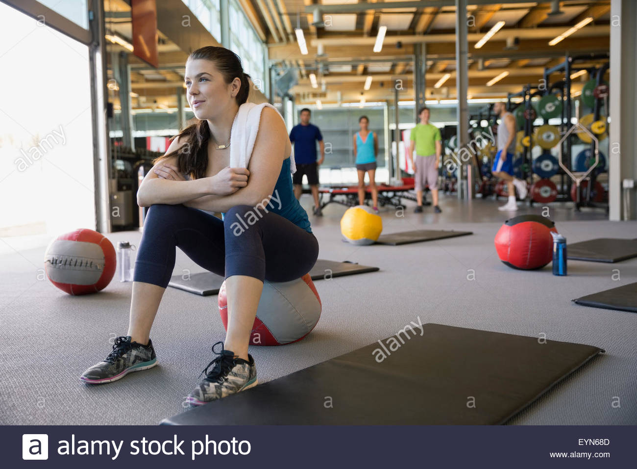 Woman sitting on medicine ball in exercise class Stock Photo Alamy