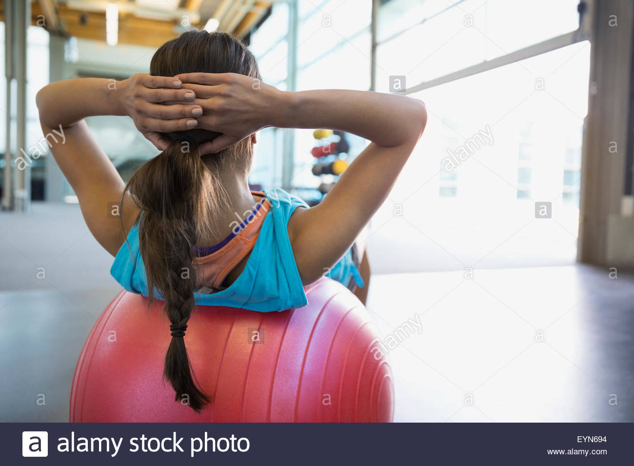 Woman doing fitness ball sit-ups at gym Stock Photo