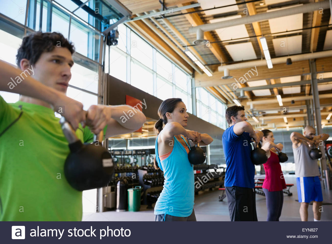 Exercise class doing kettlebell pulls in a row Stock Photo