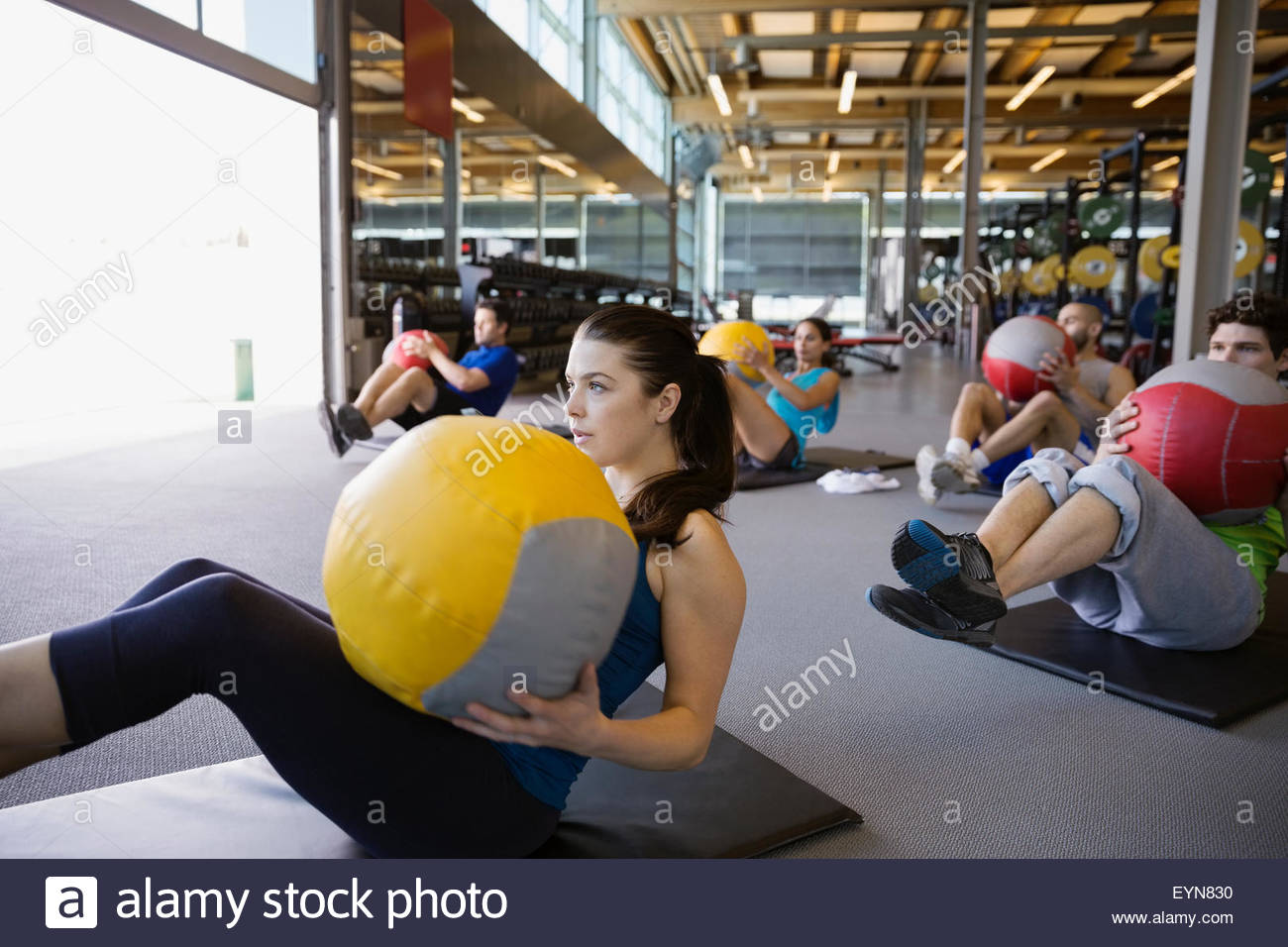 Exercise class doing seated medicine ball twists gym Stock Photo Alamy