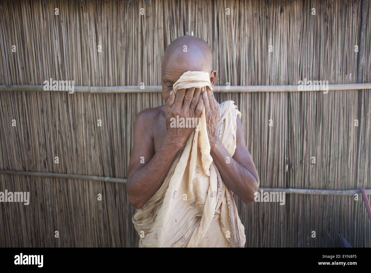 Bangladesh. 30th July, 2015. Dayamoni Barman, 65, wipes tears as she leaves her home in next couple of days at Dalaha-Khagrabari in the Bangladeshi district of Panchagarh, on July 30, 2015. Bangladesh and India will this week finally swap tiny islands of land, ending one of the world's most difficult border disputes that has kept thousands of people in stateless limbo for almost 70 years. © Suvra Kanti Das/ZUMA Wire/Alamy Live News Stock Photo