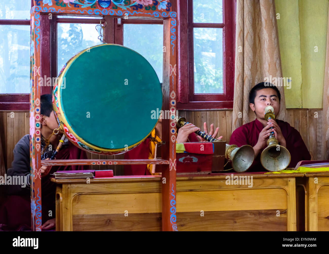 Buddhist priests, Lamas, praying inside a monastery in India, playing traditional flute, gong with copy space Stock Photo