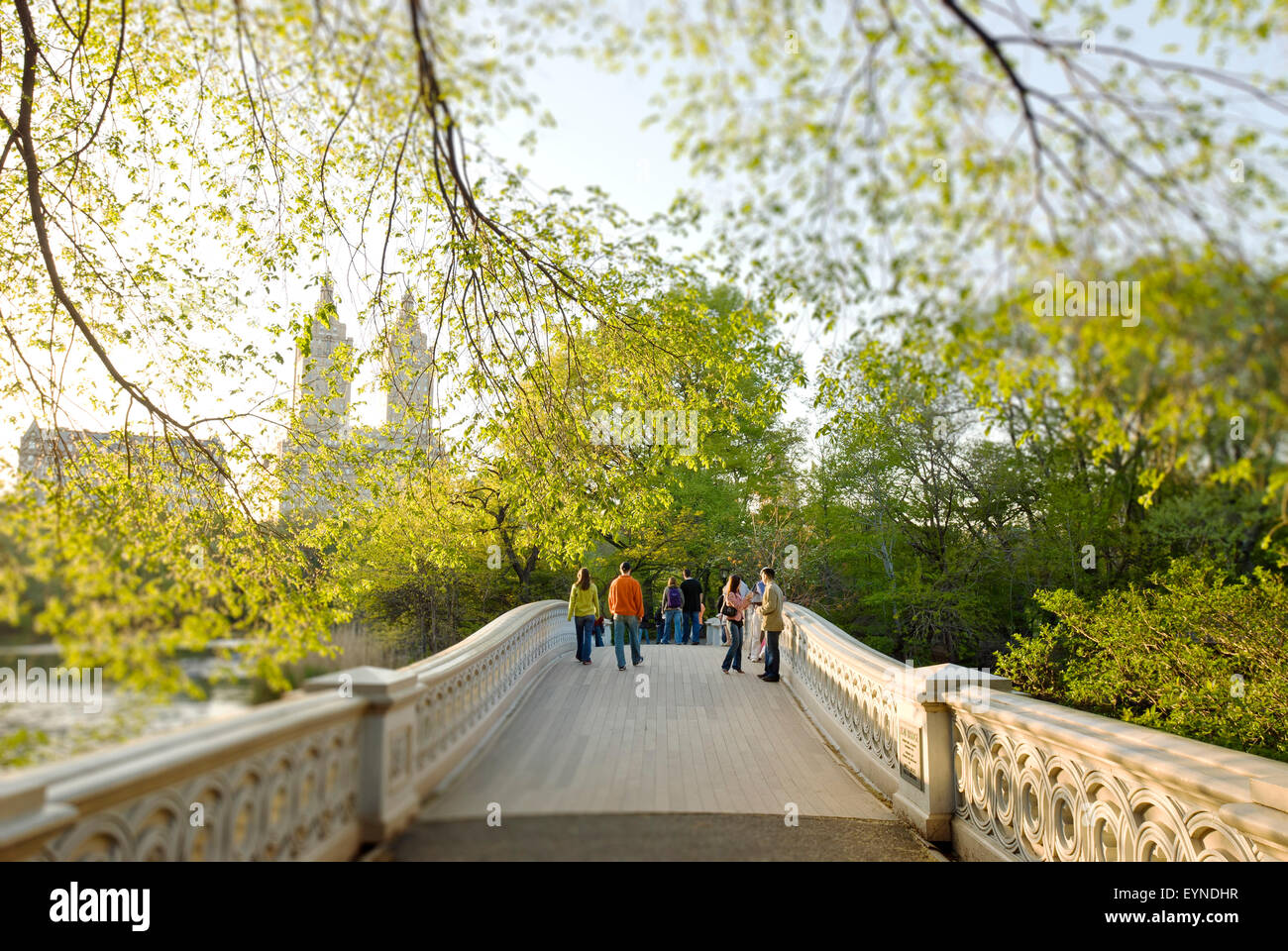 New York City, Central Park, people on Bow Bridge in springtime, view of Central Park West Skyline, the San Remo Apartments Stock Photo
