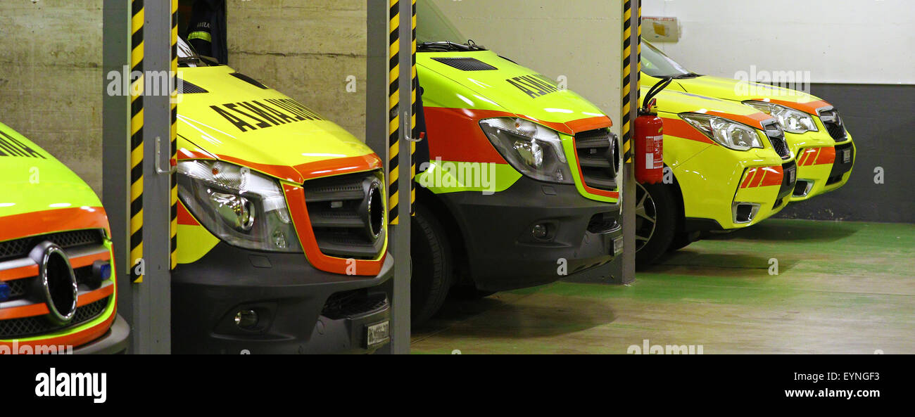 Bright yellow ambulance parked in a line of emergency vehicles during