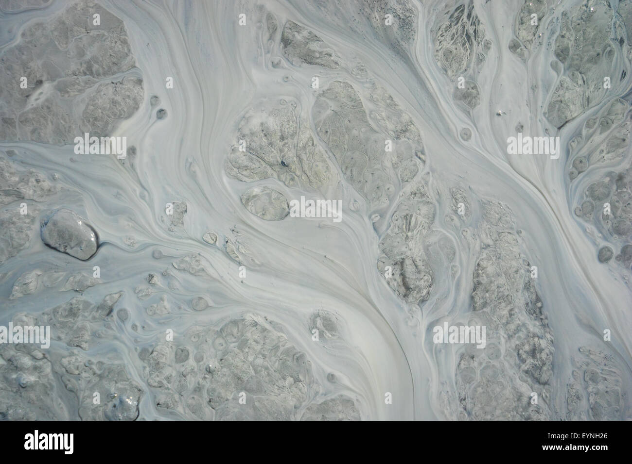 Pattern of silt and mud flow in dirty stream in Alaska. Stock Photo