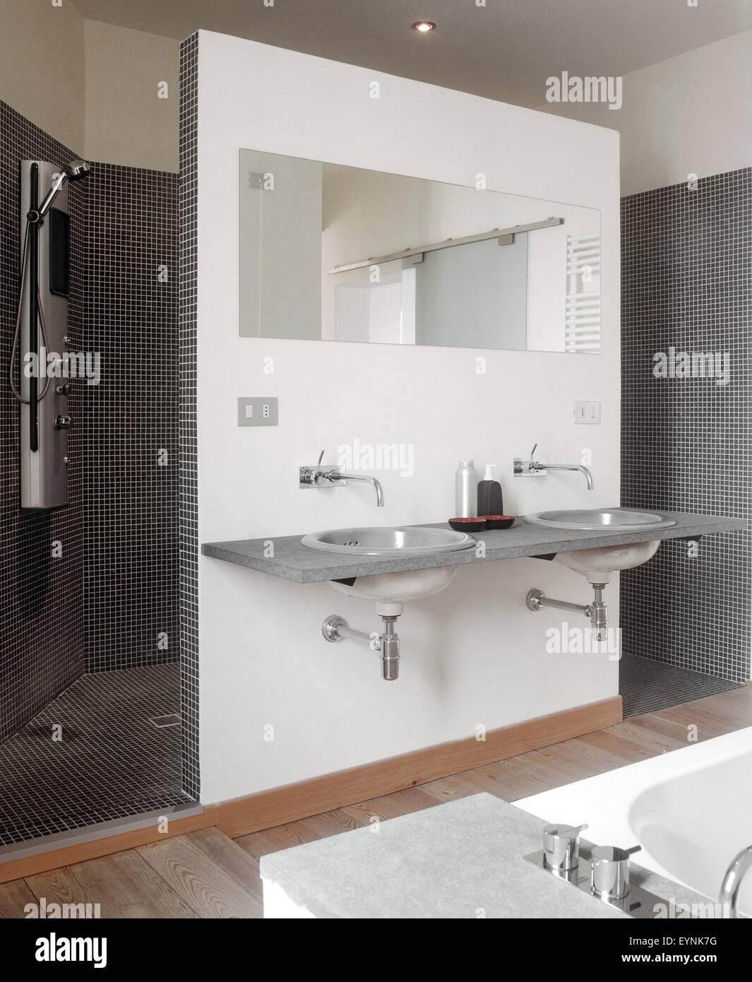 interior view of a modern bathroom in foreground the Vanity basin and mirror overlooking on shower cubicle Stock Photo