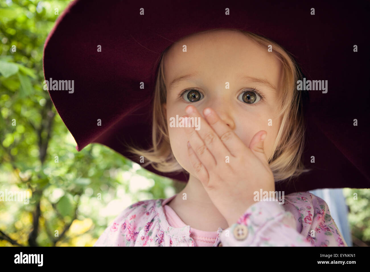 Toddler with hand over mouth in astonishment Stock Photo
