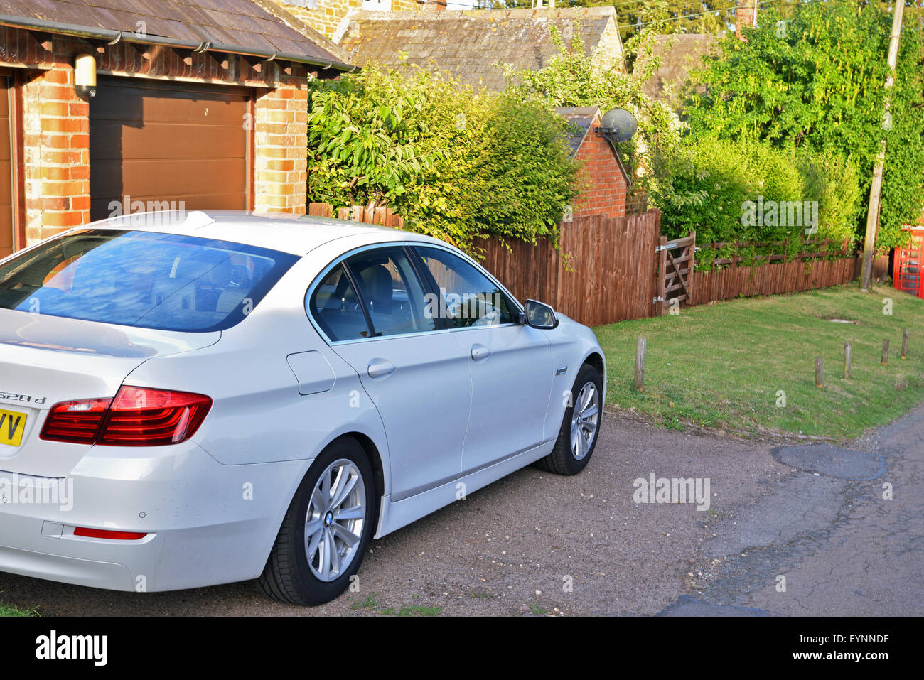 White BMW 520 car parked on side of road in Village location United Kingdom Stock Photo
