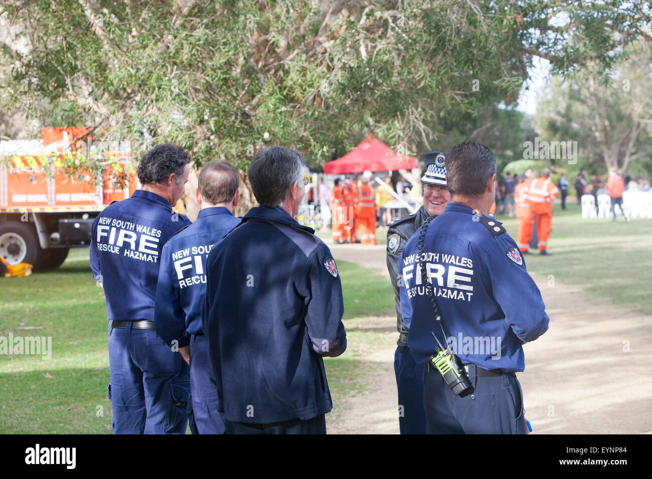 australian fire officers firemen talking to a police officer at a military tattoo in Sydney,australia Stock Photo