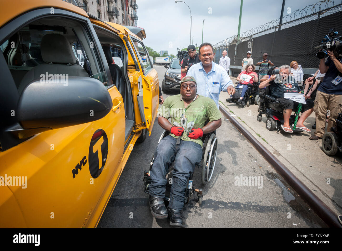 A protester arrives via accessible taxi to the Taxis For All Campaign protest in front of Uber headquarters in West Chelsea in New York on Thursday, July 30, 2015. The protesters had a 'roll-in' calling on the company to stop discriminating against the disabled by requiring handicapped accessible vehicles. Out of 20,777 Uber cars on the road not one of them is wheelchair accessible. (© Richard B. Levine) Stock Photo