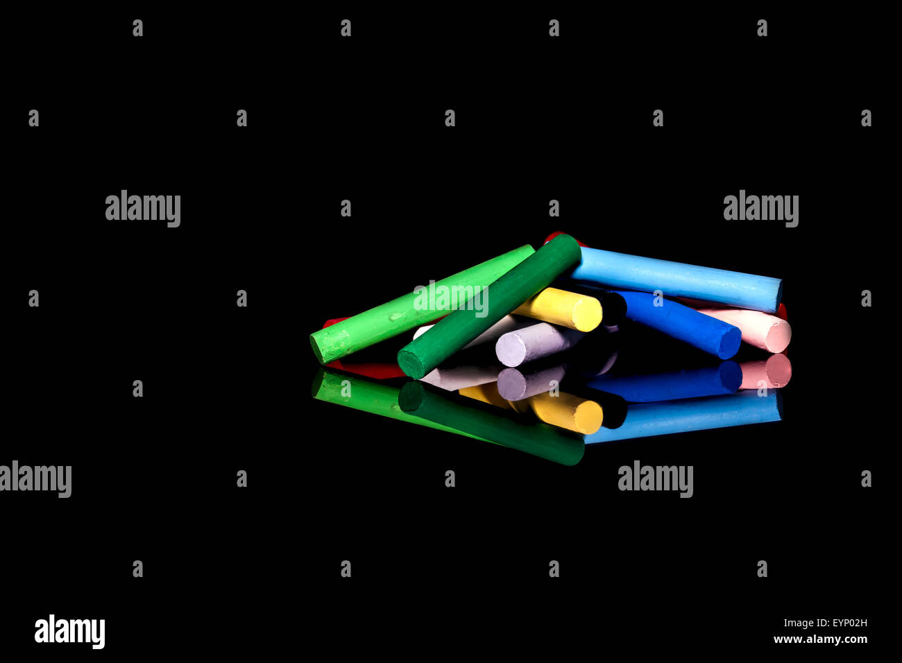twelve oil pastels on a black background with reflection Stock Photo