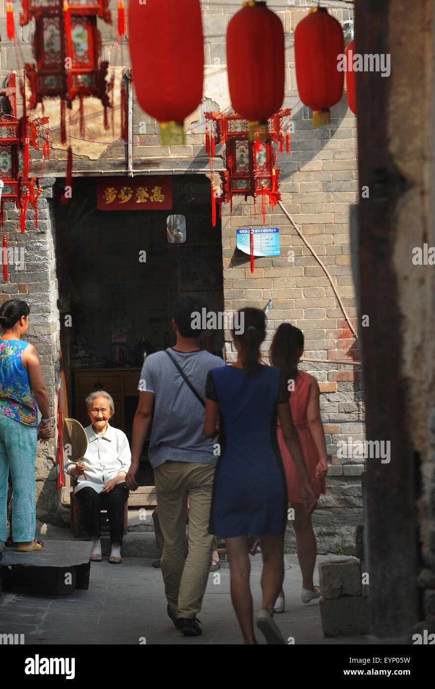 Ankang, China's Shaanxi Province. 2nd Aug, 2015. Toursits talk with a senior resident in Shuhe Town, Xunyang County, in northwest China's Shaanxi Province, Aug. 2, 2015. Located 53 kilometers to the east of Xunyang County, Shuhe Ancient Town was once a famous port in China's maritime history. The town highlights old streets full of stores and seller stands. Visitors could touch the stone walls of thousand-year-old castles, and enjoy the beauty of ancient buildings. Credit:  Tao Ming/Xinhua/Alamy Live News Stock Photo