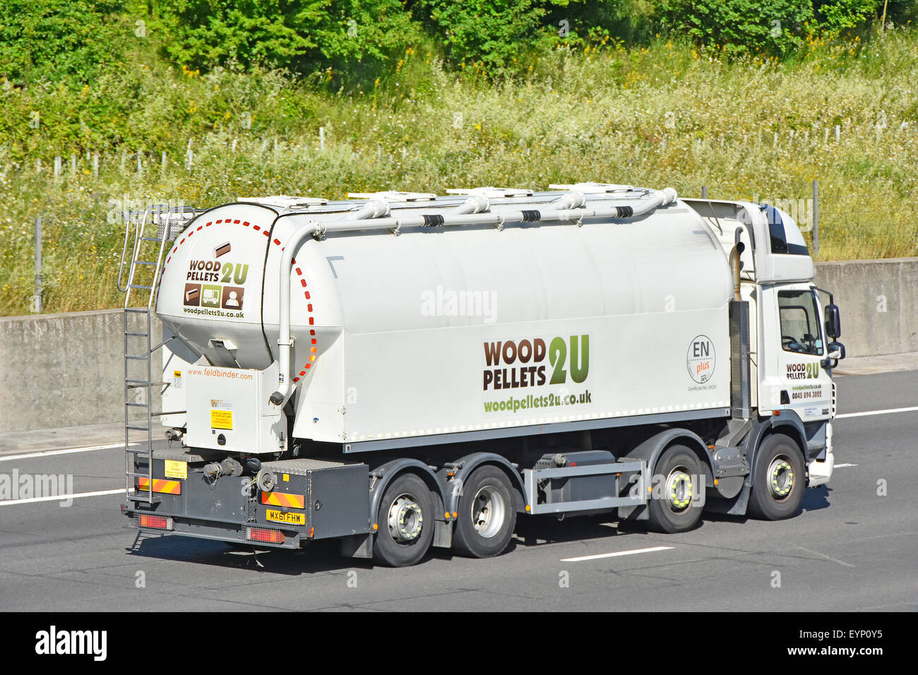 Back and side view Wood Pellets bulk blown fuel delivery tanker hgv lorry truck driving along English M25 motorway road Essex England UK Stock Photo