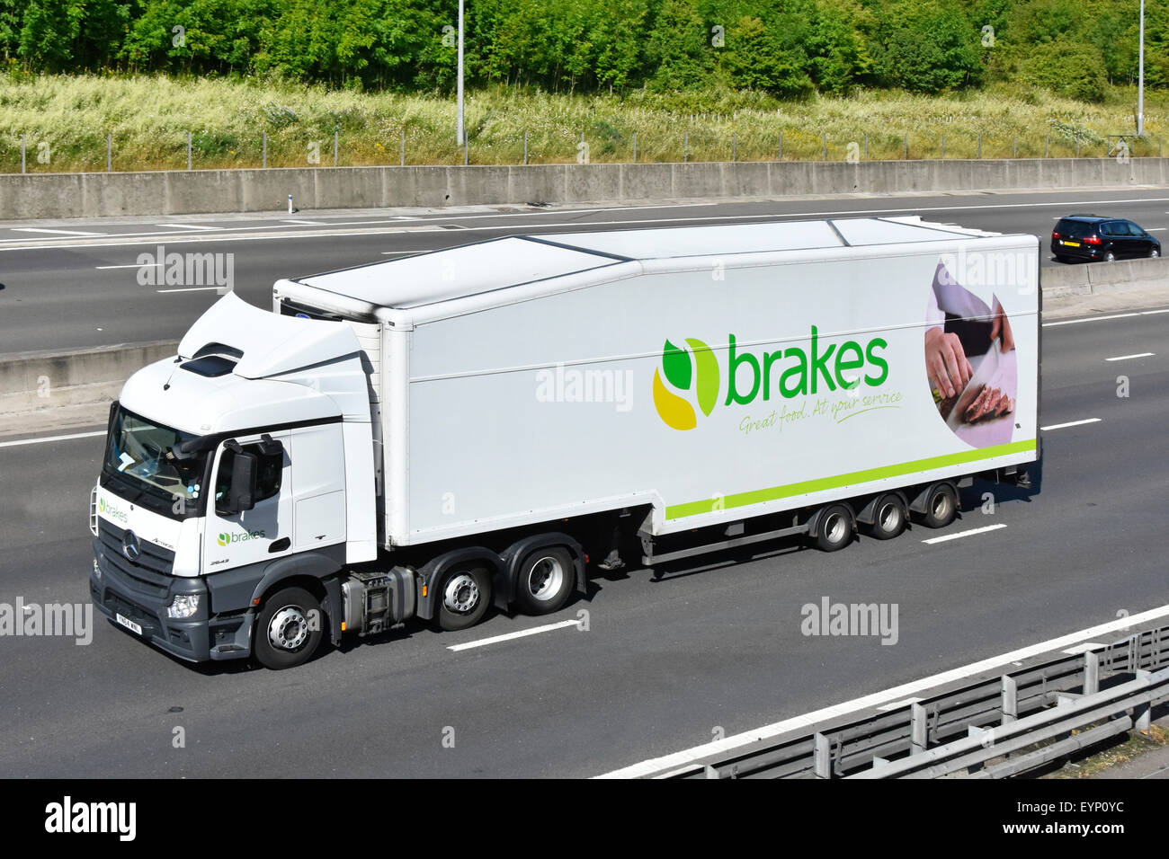 Brakes wholesale food supply chain & distribution logistics articulated trailer with advertising and hgv truck lorry driving along UK motorway England Stock Photo
