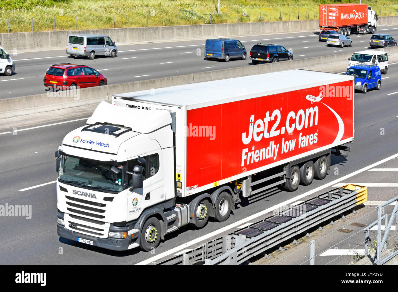 Jet2.com low cost airline advertising on articulated trailer and Fowler Welch Scania lorry truck driving along UK motorway Essex England Stock Photo