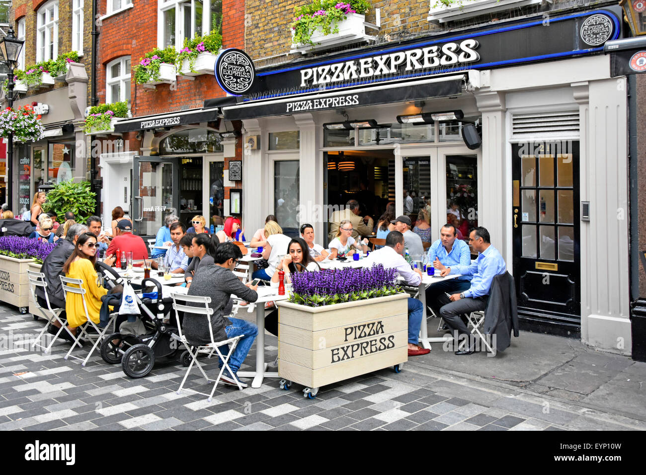 Pizza Express pizza restaurant with people eating out dining outdoors in St Christophers Place off Oxford Street alfresco dining London West End UK Stock Photo