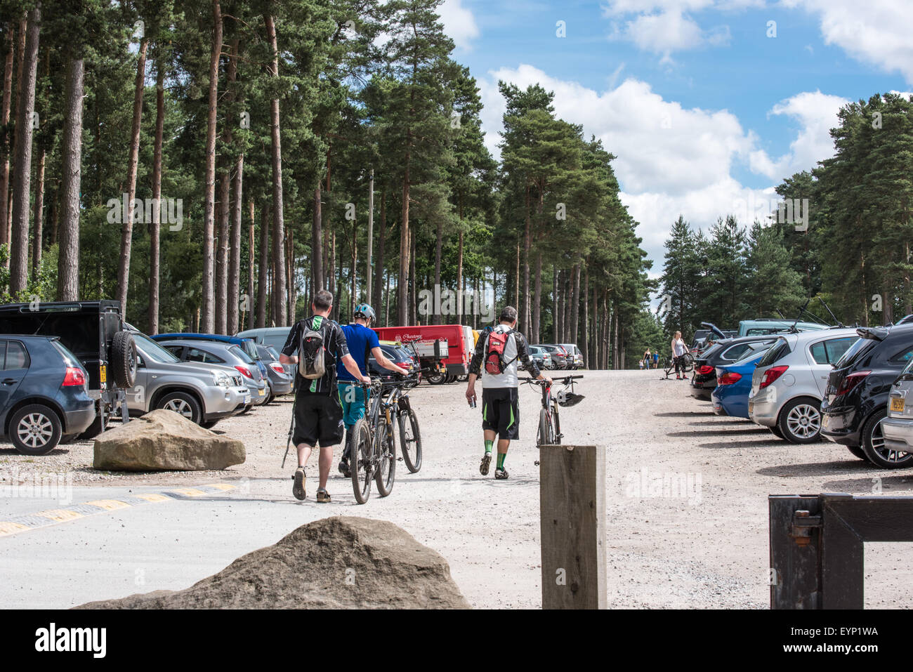 Cyclists pushing their mountain bikes oncar park at Go Ape activity centre cannock chase Staffordshire West Midlands uk Stock Photo