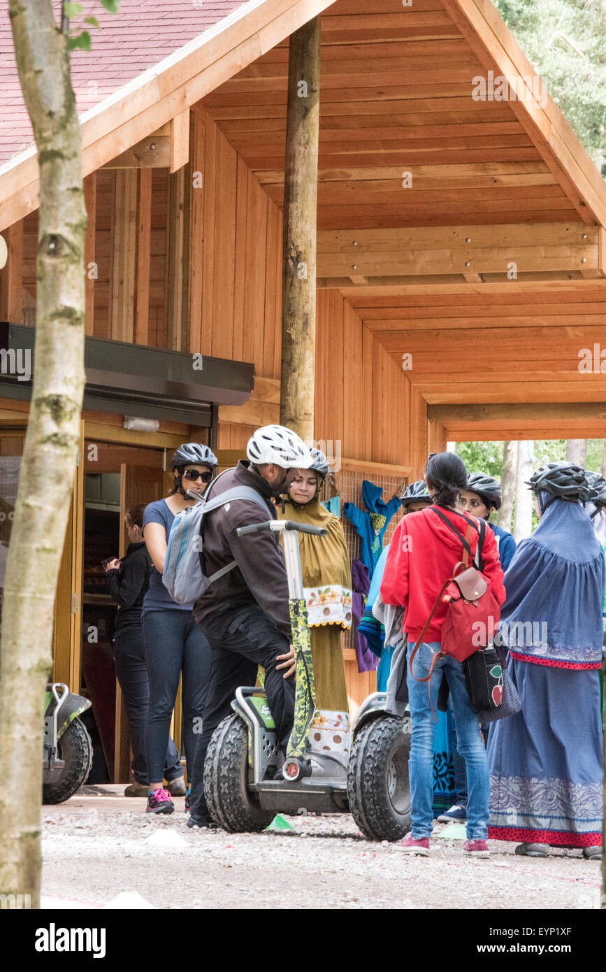 A group of Asian men and women learning to ride on segway at Go Ape activity centre Cannock Chase staffordshire uk Stock Photo