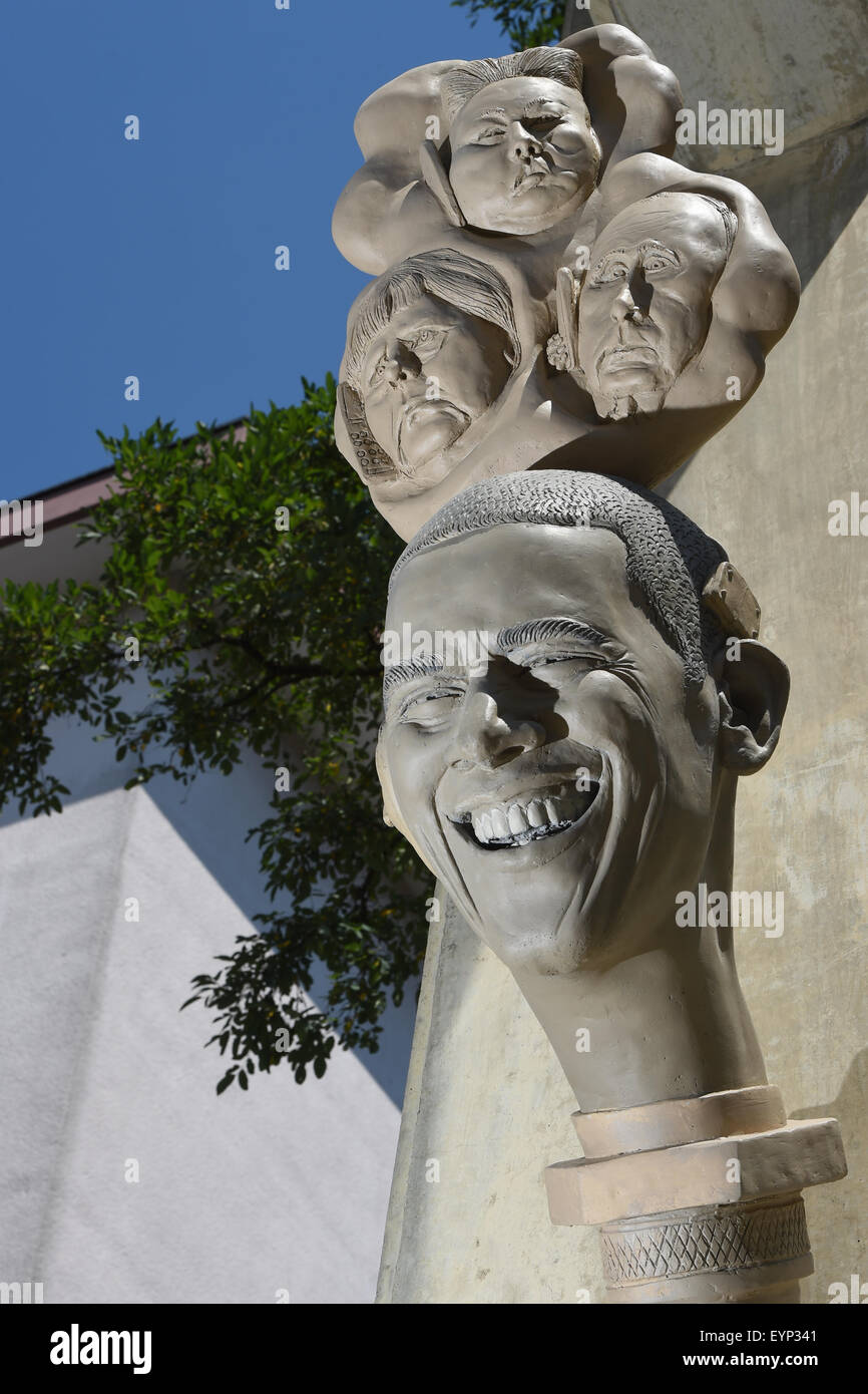 A view of a new sculpture entitled 'Paradiesschlange' (lit. paradise snake) by artist Peter Lenk shortly after its unveiling in Singen am Hohentwiel, Germany, 02 August 2015. The new figures and faces will complement Lenk's existing paradise tree. The head on the bottom depicts US President Barack Obama, with the faces of German Chancellor Angela Merkel (L), North Korean dictator Kim Jong-un (top) and Russian President Vladimir Putin piled on top. Photo: FELIX KAESTLE/dpa Stock Photo