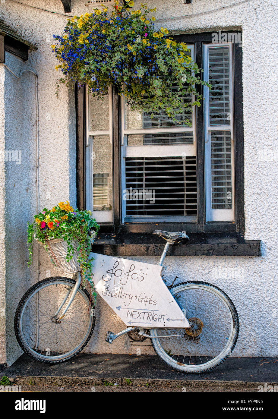 A vintage bicycle displaying directional sign to a village shop. Stock Photo