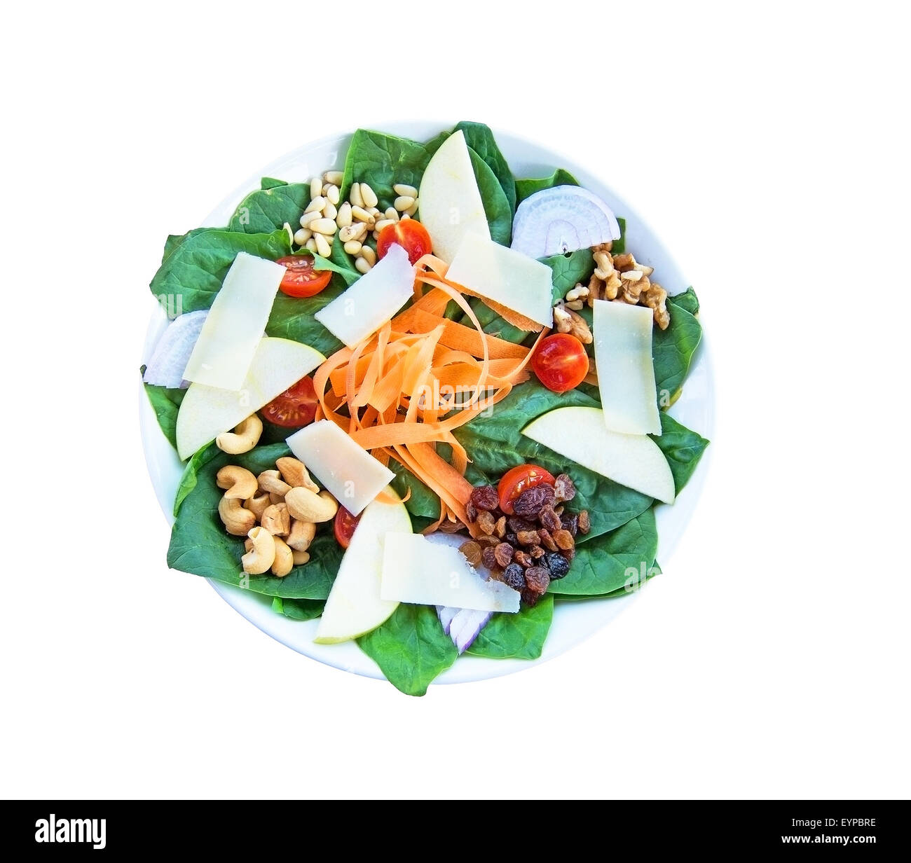 Fresh spinach salad with parmesan, nuts, carrots, tomatoes, pear, nuts and raisins. Food on white plate. Stock Photo