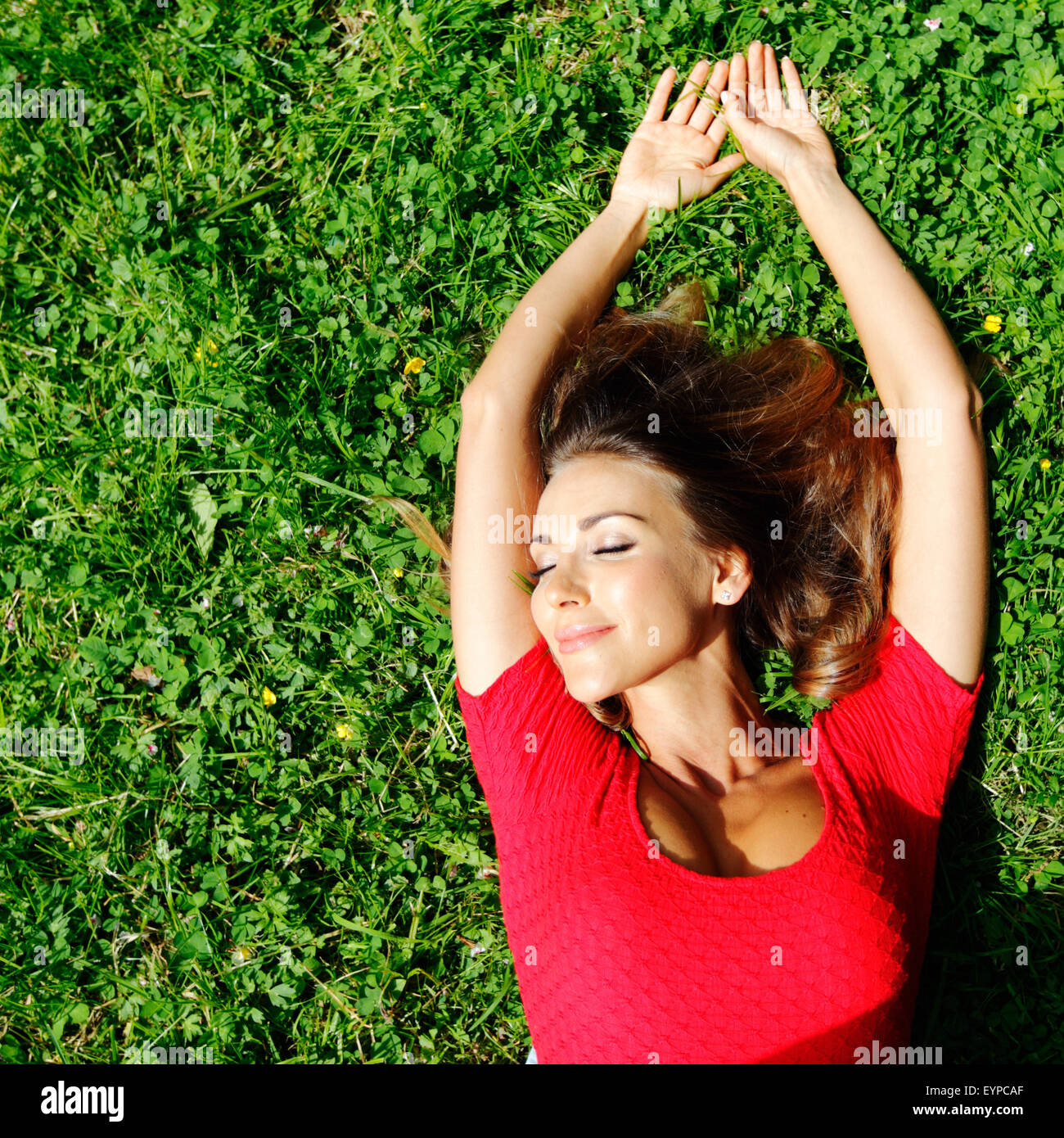 young woman in red dress lying on grass Stock Photo - Alamy